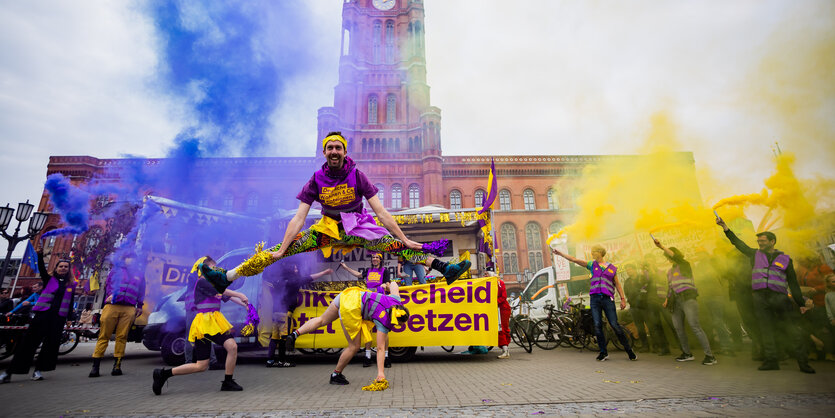 Aktivist*innen tanzen vor dem Roten Rathaus bei Pyrotechnik und guter Laune