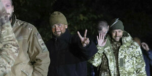 Eine Gruppe Soldaten. Einer davon macht mit seinen Fingern ein "V-Zeichen" für Victory