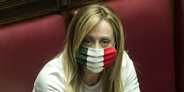 Giorgia Meloni wears a mask with the colors of the Italian mask