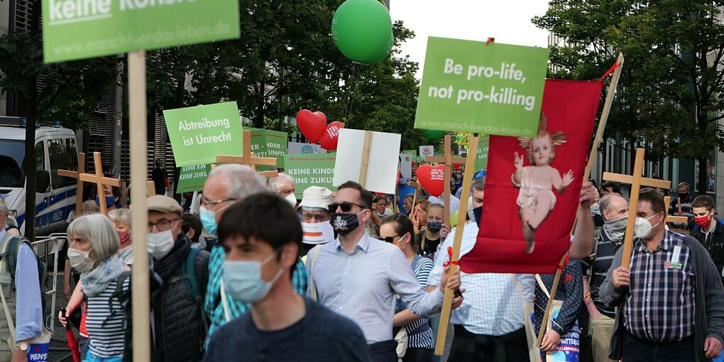 Demonstrant:innen nehmen beim Marsch fürs Leben teil und halten Schilder hoch mit "be pro life not pro killing"