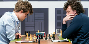 Magnus Carlsen und Hans Niemann sitzen am Schachbrett