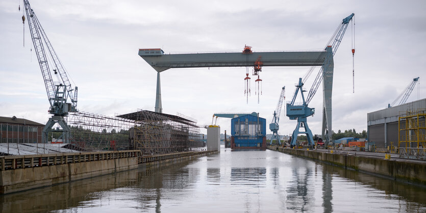 Ein großer Kran steht über dem Becken einer Werft