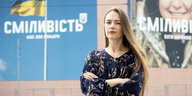 Preisträgerin Oleksandra Matwijtschuk steht vor einer Wand mit Plakaten