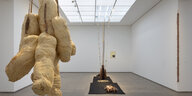 Sicht in die Ausstellung "nothing left to be": Prall gefüllte amorphe Stoffskulpturen hängen in einem Ballen von der Decke