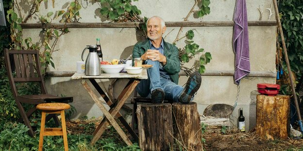 Ein Mann sitzt in einem Garten auf einer Bank und guckt in die Kamera: Ernst Paul Dörfler verbringt seine Zeit gerne im Freien