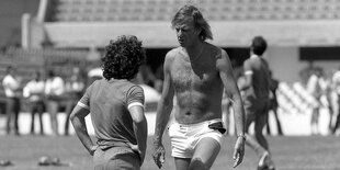 Cesar Luis Menotti mit freiem Oberkörper unterhält sich mit Diego Maradona