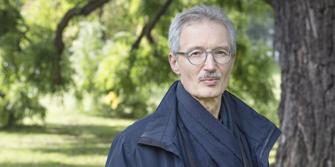 Bernhard Docke steht vor einem Baum