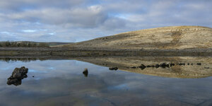 Die Felsen des Burren spiegeln sich im Wasser