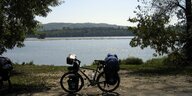 ein Fahrrad mit Gepäck steht am Ufer der Donau