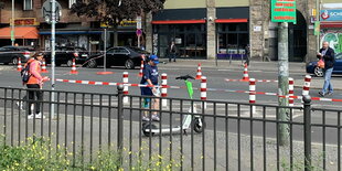 Straßenszene in Berlin, Frauen in Warnwesten mit Flatterband in der Hand