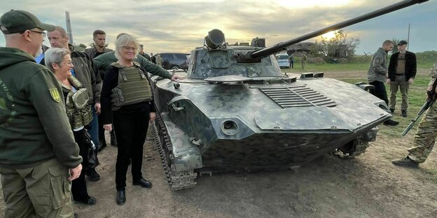 Defense Minister Christine Lambrecht in a protective vest in front of a tank