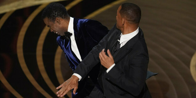 Will Smith slaps Chris Rock on a stage.