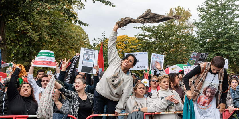 Wütende Demonstrant*innen stehen hinter Absperrgittern