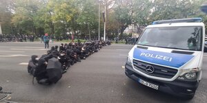 Gegendemonstranten sitzen auf dem Boden, während einer Demonstration die sich gegen die Energiepolitik der Bundesregierung, Russlandsanktionen und Coronamaßnahmen richtet.