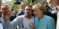 Angela Merkel posiert für ein Selfie mit einem Geflüchteten