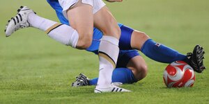 Detailaufnahme von den Beinen zweier Fußballerinnen im Zweikampf