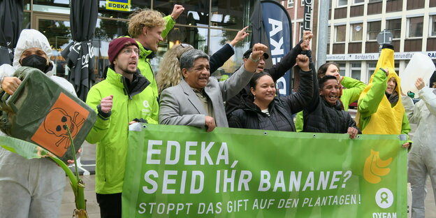 Eine Gruppe protestiert vor einem Edeka mit einem Tranparent: "Edeka, seid ihr Banane ? Stoppt das Gift auf den Plantagen"