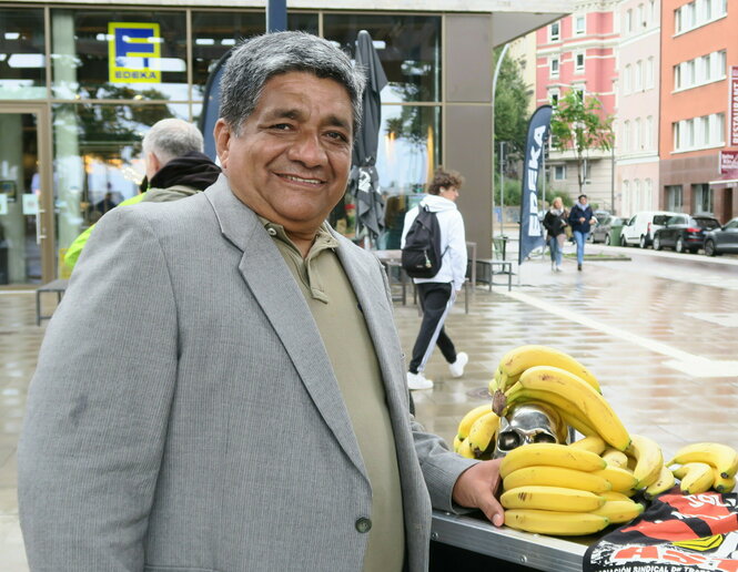 Der Gewerkschafter Jorge Acosta steht vor einem Stand mit Bananen