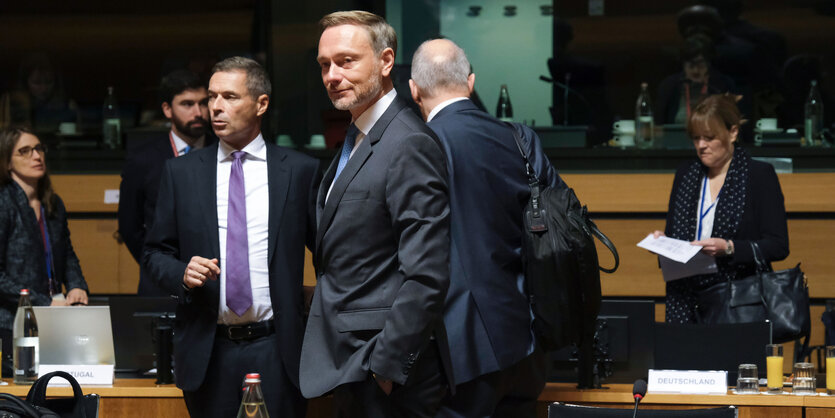 Christian Lindner steht in einem Sitzungssaal, umgeben von Kollegen und lächelt in die Kamera