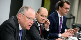 Bundeskanzler Olaf Scholz (M, SPD), Stephan Weil (l, SPD), Ministerpräsident von Niedersachsen, und Hendrik Wüst (r, CDU), Ministerpräsident von Nordrhein-Westfalen, äußern sich bei einer Pressekonferenz nach den Beratungen von Bundeskanzler Scholz und der Bundesregierung mit den Regierungschefinnen und Regierungschefs der Länder im Bundeskanzleramt