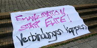 Banner liegt auf Treppenstufen mit der Aufschrift: "Emanzipation statt Elite! Verbindungen kappen"