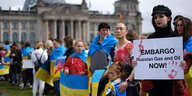 Ukrainer eingehüllt in ihre Landesflagge fordern ein Embargo für russisches Gas und Öl vor dem reichstag