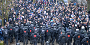 Polizisten halten eine Menschenmenge auf