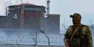 Ein Soldat mit russischer Flagge auf seiner Uniform steht Wache in der Nähe des Kernkraftwerks Saporischschja