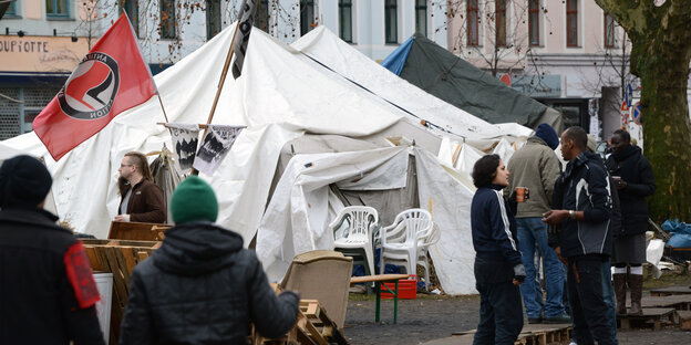 Weißes Zelt auf dem Oranienplatz, diskutierende Menschen