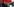 Der junge SPD-Landtagskandidat Besian Krasniq steht neben dem SPD-Generalsekretär Kevin Kühnert unter einem roten SPD-Schirm auf dem Marktplatz von Quakenbrück.