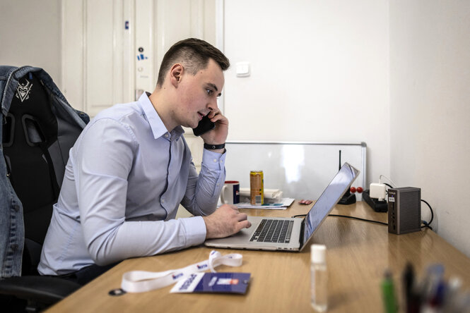 Stepan Putilo sitzt an seinem Schreibtiscch mit Labtop und telefoniert