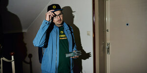Norbert Gast steht mit Flyern vor einer Haustür