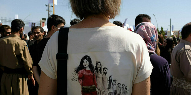Eine Frau hat das Portrait von Mahsa Amina auf ihr T-shirt gedruckt