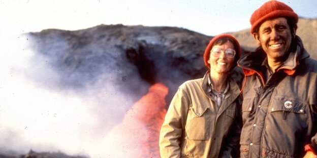 Ein Mann und eine Frau vor dem Krater eines Vulkans