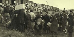 Juden stehen vor einem Zug, mit dem sie deportiert werden