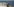 Zwei menschen am Meer, im Hintergrund sind Patrouillenboote zu sehen