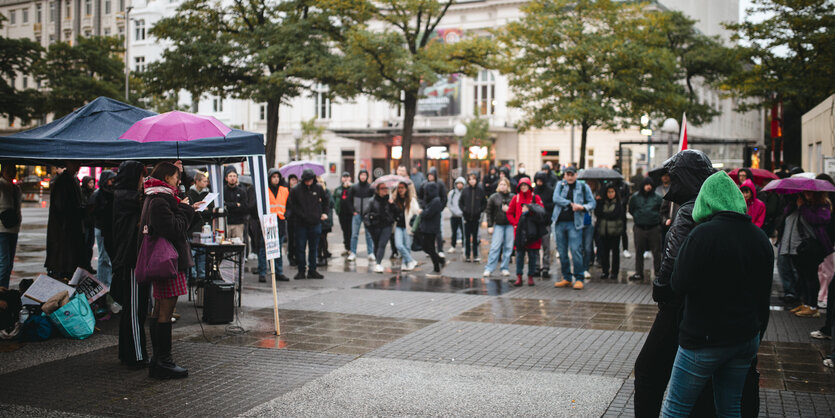 Menschen stehen auf einer Kundgebung auf einem großen Platz