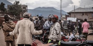 Männer mit Motorrädern stehen an einer Straßenkreuzung und unterhalten sich