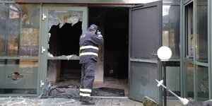 Ein Polizist fotografiert ein durch einen Brand zerstörtes Restaurant