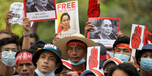 Proteste mit Plakaten, die Suu Kyi zeigen