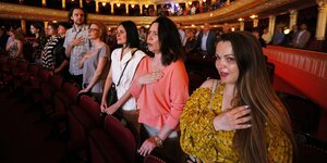 Menschen stehen in den Rängen des Opernhauses von Odessa und singen die ukrainische Nationalhymne