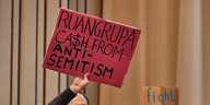 Protestierende halten in der Aula der Hochschule für bildende Künste Hamburg (HFBK) Tranparente mit der Aufschrift "Ruangrupa Ca$h From Antisemitism" und "Fight BDS" hoch