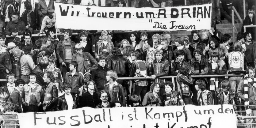 Fußballfans in einem Stadion halten ein Trabsparent, auf dem steht: Wir trauern um Adrian. Die Treuen.