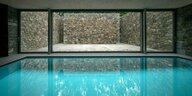 Schwimmbad mit großen Fenstern und gemauerten Wänden an der Terrasse