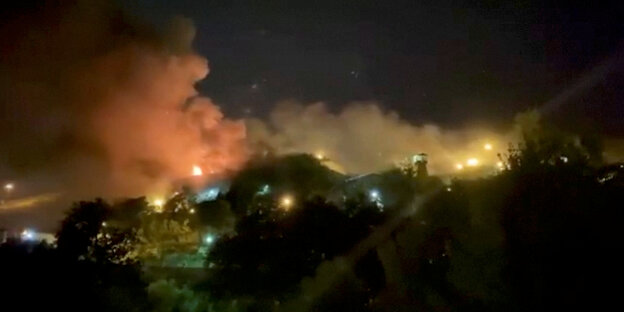 Eine Nachtaufname, die den vom Feuer beleuchteten Rauch über den Ewin-Gefängis zeigt