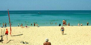 Menschen unterschiedlichsten Alters am Strand im Sommer