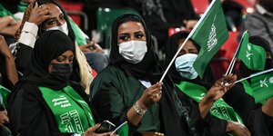 Saudi-arabische Zuschauerinnen im Stadion mit Fähnchen