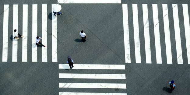 A few people cross zebra crossings on the street