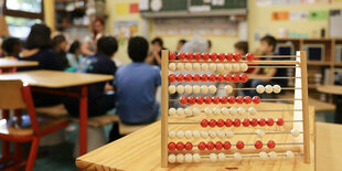 Schüler am Morgen in der Grundschule Feldstraße im Unterricht zusammen, im Vordergrund steht ein Abacus