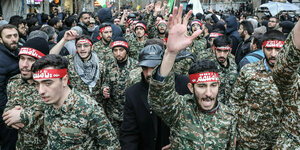 Mitglieder der iranischen paramilitärischen Basij-Miliz in Kampfanzügen nehmen an einem Trauerzug teil